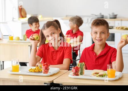 Pupils having healthy lunch in classroom Stock Photo
