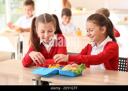 Pupils having healthy lunch in classroom Stock Photo