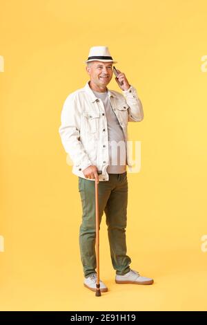 Senior man talking by mobile phone on color background Stock Photo