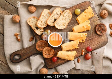Composition with pieces of tasty cheese and grapes on wooden background Stock Photo