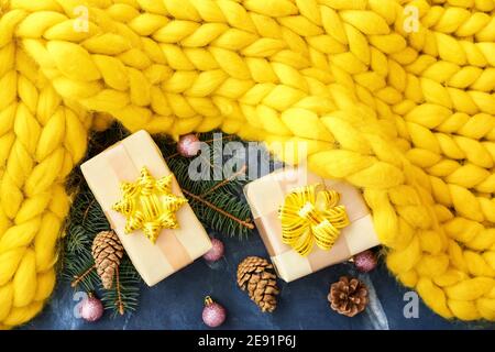 Christmas composition with knitted plaid and gift boxes on color background Stock Photo