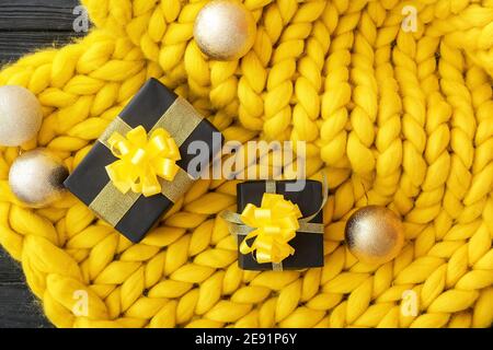 Gift boxes with Christmas balls on knitted plaid Stock Photo