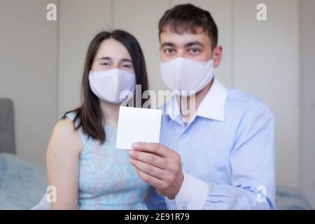 Blurred man and woman holding sheet of white paper for your text Stock Photo