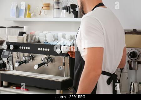 Barista making hot coffee in cafe Stock Photo