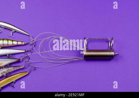 Special hook for wobblers and other lures. A metal device with ropes for pulling baits hooked on underwater snags out of the water. Fishing equipment. Stock Photo