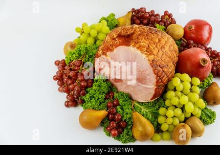 Boneless whole pork ham with fresh fruits. Healthy food. Easter meal. Stock Photo