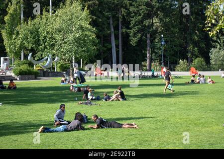 Whistler, Canada - July 5,2020: People are sitting on the green lawn on a sunny day in Whistler Village Stock Photo