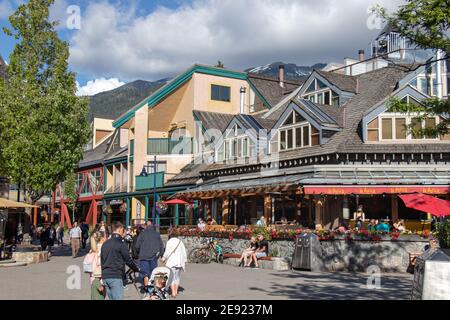 Whistler, Canada - July 5,2020: Whistler Village full of people on a sunny day with mountain view in the background Stock Photo