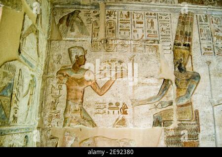 Ancient Egyptian bas relief showing the Pharaoh Ptolemy IV making an offering to Amun. Deir el Medina temple, Luxor, Egypt. Ancient temple, over 1000 Stock Photo