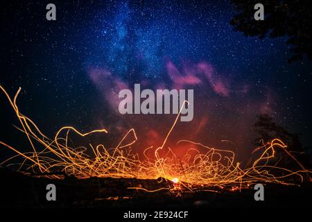 Bright bonfire sparks under starry sky Stock Photo