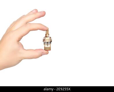 Plumber holds in hand a faucet axle on a white background, isolate. The concept of a leakage strap in the mixer tap when replacing the valve faucet ax Stock Photo
