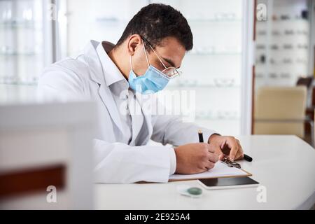 Serious concentrated optometrist working in his office Stock Photo