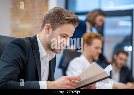 Attentive man in suit reading document Stock Photo