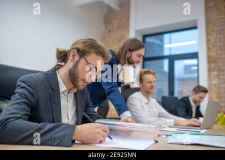 Man in glasses with pencil looking at document Stock Photo