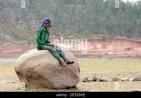 A Tigray boy sitting on a big rock boulder in northern Ethiopia. Stock Photo