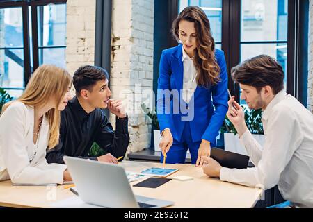 Businesswoman show graph on tablet to colleagues Stock Photo