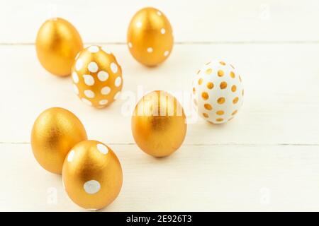 Easter festive decoration.Close up of easter eggs colored with golden paint on wooden background. Various dotted designs. Stock Photo