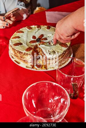 Party cake, cut into pieces with a knife on the table Stock Photo