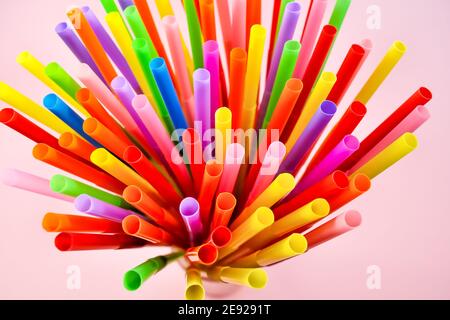 Multicolored cocktail straws on a pink background. Colorful cocktail accessory and decoration. Stock Photo