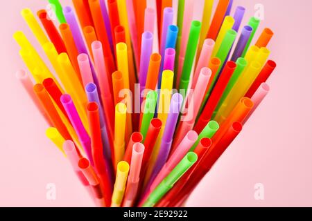 Multicolored cocktail plastic straws on a pink background. Colorful accessory and decoration for cocktails and drinks party. Stock Photo