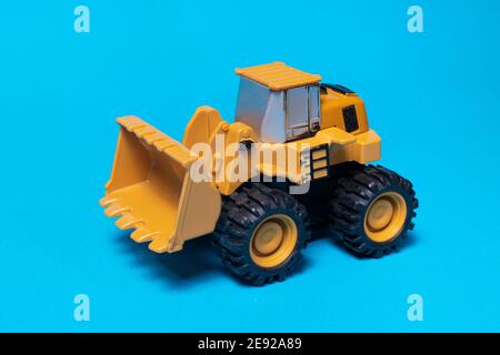 Toy typewriter tractor bulldozer on a blue background. Toy for children. Stock Photo