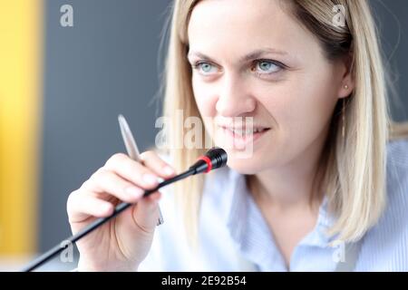 Business woman speaking into microphone at conference Stock Photo