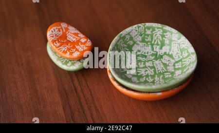 Set of empty green and orange ceramic dishes and stands for sushi sticks on wooden background Stock Photo