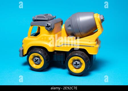 Orange concrete mixer toy typewriter on a blue background. A banner with a place for text for a toy store Stock Photo