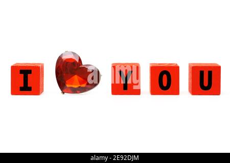 I love you phrase made of small red wooden blocks and a faceted ruby heart. Valentine's Day and love concept. Stock Photo