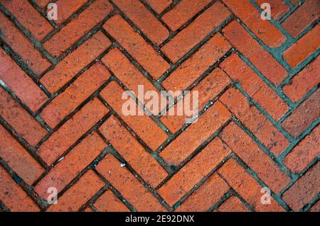 Road pavement made of stone. A pedestrian pavement or stone path made of blocks lined with herringbone. Stock Photo