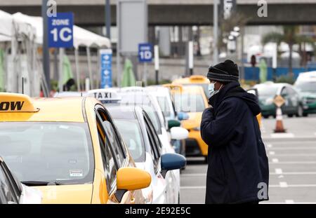 (210202) -- LOS ANGELES, Feb. 2, 2021 (Xinhua) -- A taxi driver wearing a face mask waits for customers at the International Airport in Los Angeles, California, the United States, on Feb. 1, 2021. Beginning Tuesday, Americans are required to wear face masks while traveling on domestic public transport as part of a national strategy to curb the spread of COVID-19.   The rule, issued by the U.S. Centers for Disease Control and Prevention (CDC), applies to passengers on airplanes, trains, subways, buses, taxis and ride-shares. And it extends to waiting areas such as airports, train platforms and Stock Photo
