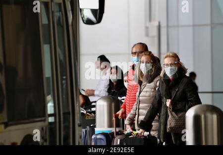 (210202) -- LOS ANGELES, Feb. 2, 2021 (Xinhua) -- Travelers with face masks wait for public transportation services at the International Airport in Los Angeles, California, the United States, on Feb. 1, 2021. Beginning Tuesday, Americans are required to wear face masks while traveling on domestic public transport as part of a national strategy to curb the spread of COVID-19.   The rule, issued by the U.S. Centers for Disease Control and Prevention (CDC), applies to passengers on airplanes, trains, subways, buses, taxis and ride-shares. And it extends to waiting areas such as airports, train pl Stock Photo