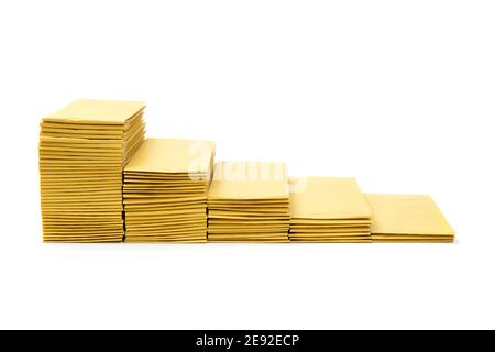 Side view of five stacks of yellow mail envelopes arranged in descending order imitating stairs isolated on white Stock Photo