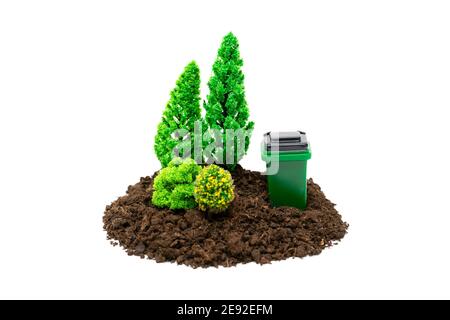 Miniature clean forest, with a garbage container isolated on white background. The concept of proper waste management to keep forests clean. Stock Photo