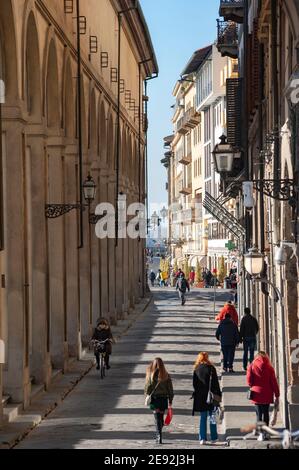 Florence, Italy - 2020, January 18: People walking in the streets, along the arches of the Corridoio Vasariano, in a sunny day. Stock Photo