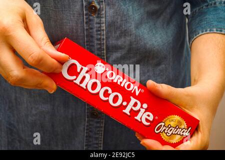 Tambov, Russian Federation - October 30, 2020 Woman opening Orion Choco-Pie box. Stock Photo