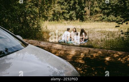 Family spending leisure time while sitting in forest during vacation Stock Photo