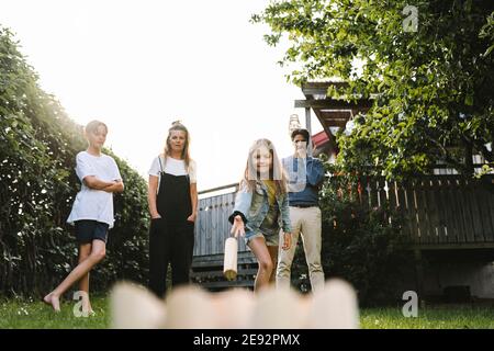 Girl playing molkky with family in back yard Stock Photo