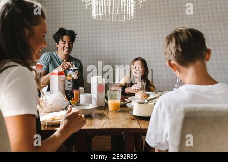 Happy family having breakfast on dining table at home Stock Photo