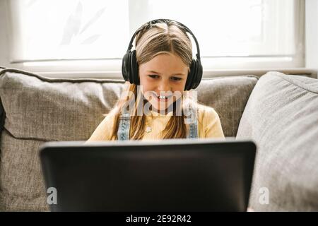 Smiling girl studying on laptop at home Stock Photo