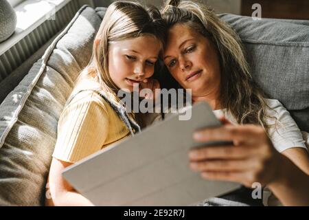 Mother and daughter using digital tablet at home Stock Photo
