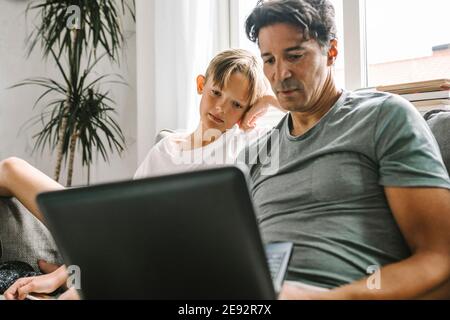 Father and son using laptop at home Stock Photo