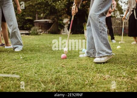 Low section of teenage girl playing polo with family in front yard Stock Photo