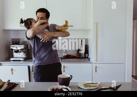 Father playing with son in kitchen at home Stock Photo