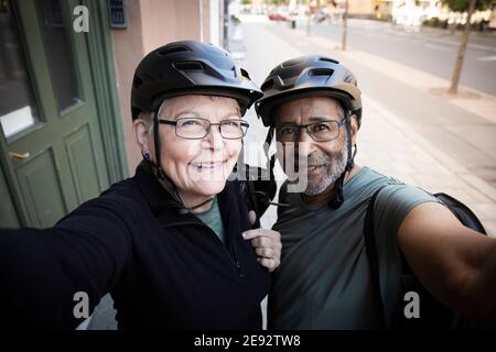 Happy couple taking selfie outside house Stock Photo
