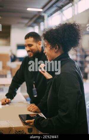 Smiling male and female manual workers at warehouse Stock Photo