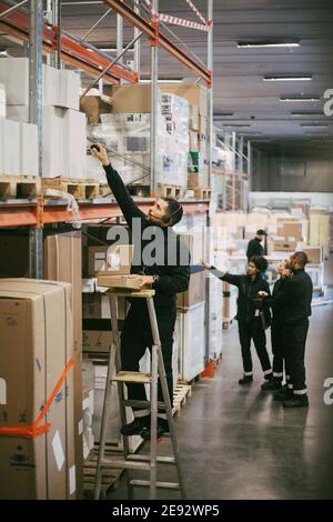 Male professional analyzing strategy while standing by glass in office ...