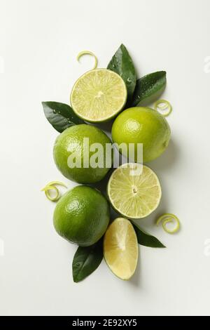 Ripe lime, leaves and peel on white background Stock Photo