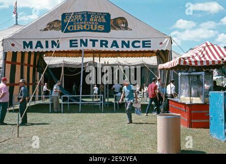 Workers make ready the main entrance to the big top at the Clyde Beatty and Cole Bros Brothers Combined Circus, USA c.1960. The painted banner displayed has a lion and tiger on it. This image is from an old American amateur Kodak colour transparency. Stock Photo