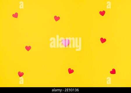 Red and pink hearts isolated on an empty colorful yellow background. Symbol of love for Happy Women's, Mother's, Valentine's Day, Birthday greeting romantic postcard. Flat lay, top view, copy space Stock Photo